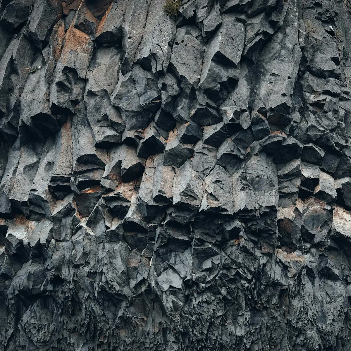 Close-up of dark columnar dolerite rock face, near-black basalt columns
