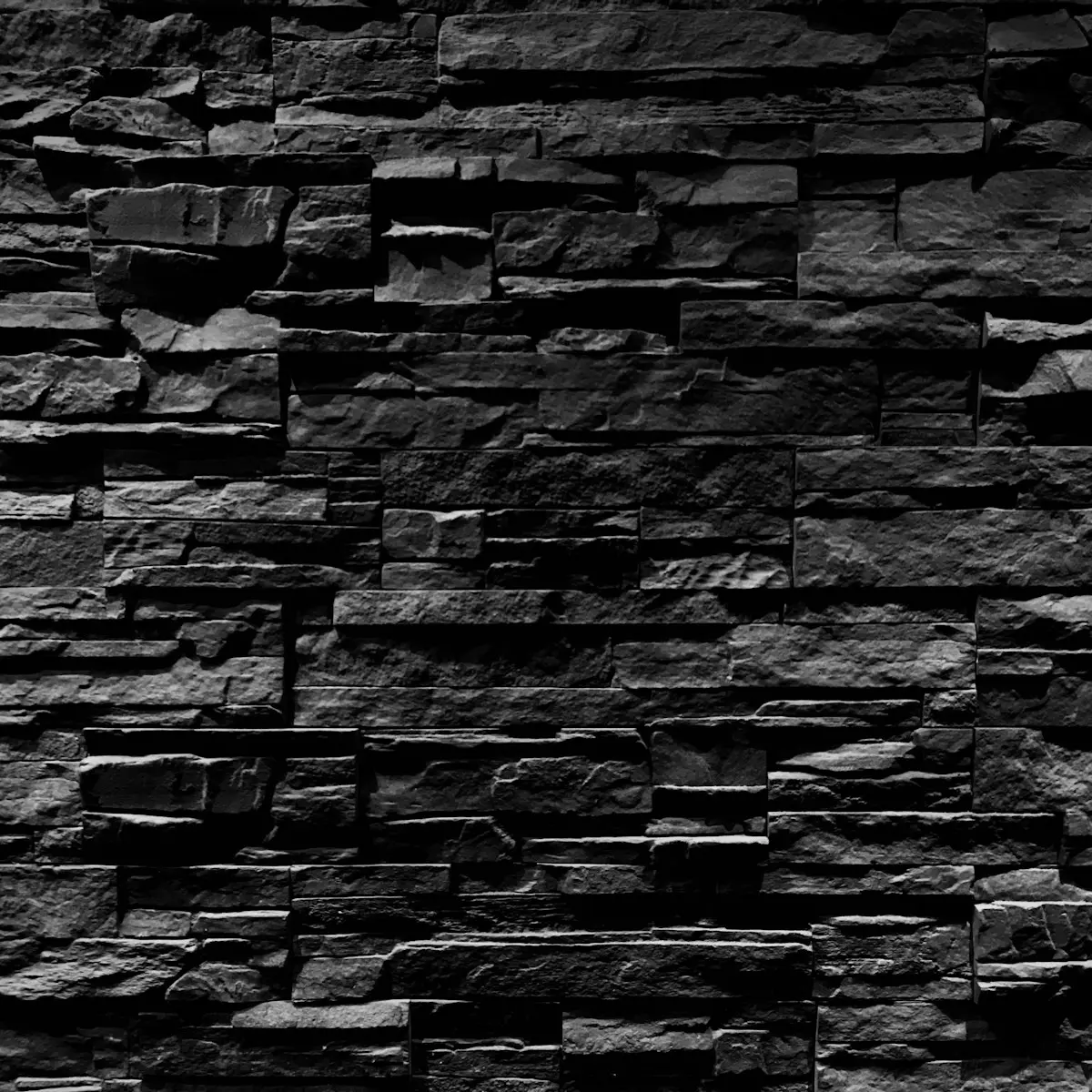 Dry-stacked black stone wall, deep recessed dark joints