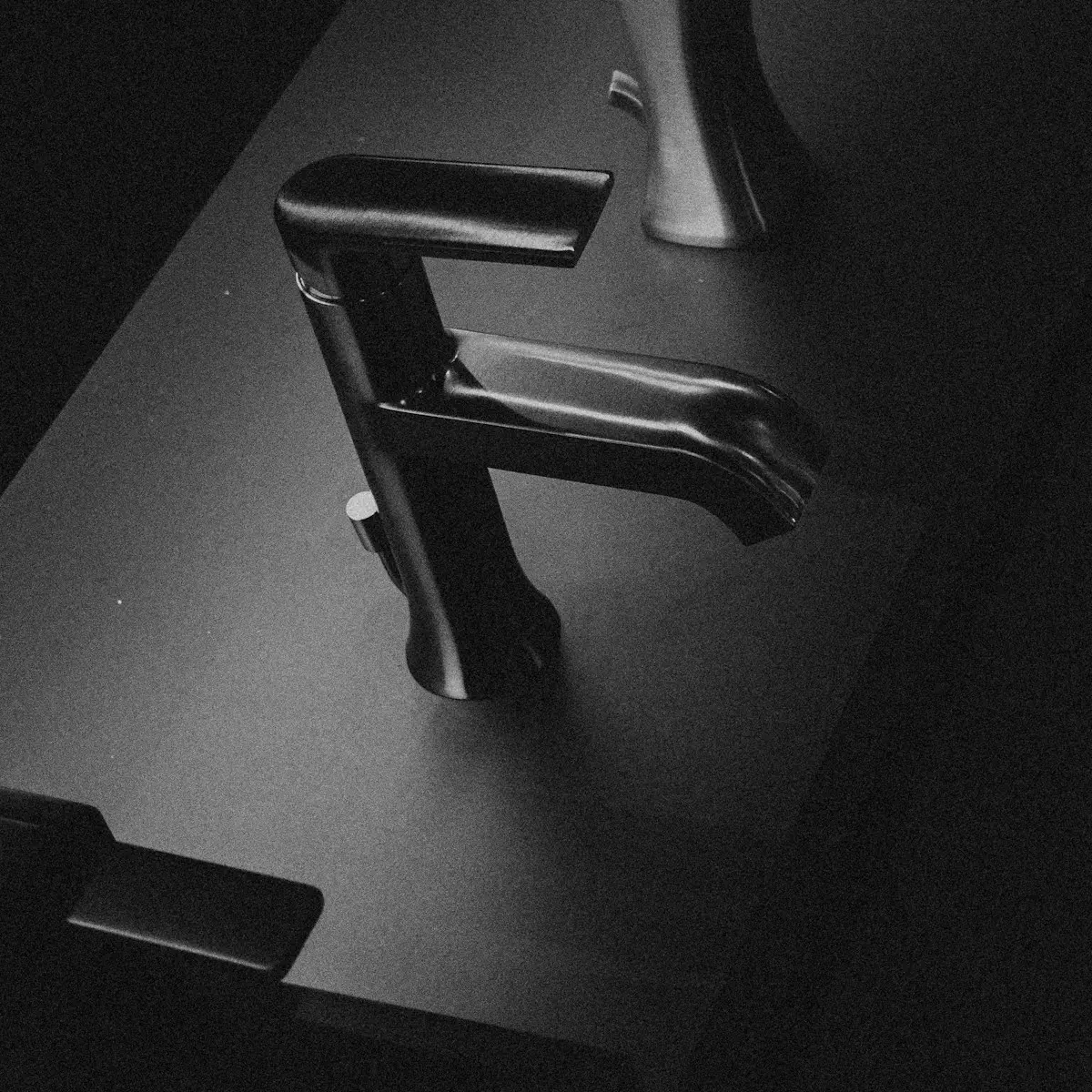 Matte black tapware on a dark charcoal surface