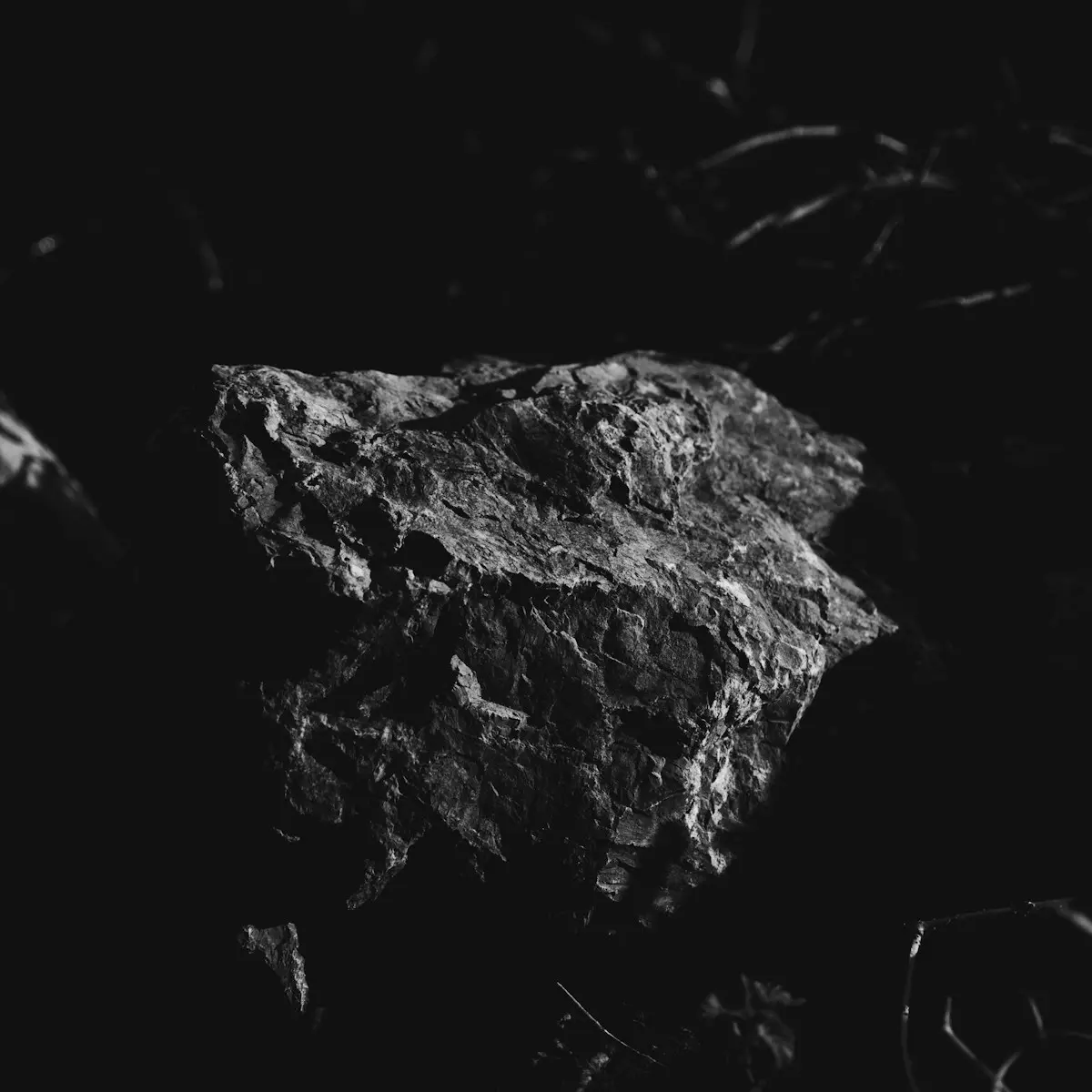 Rough fieldstone emerging from darkness